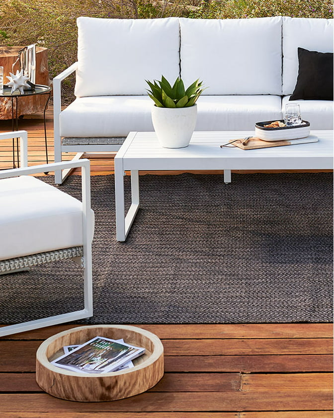 A modern white outdoor conversation set on a wooden patio. Links to patio furniture on dxfairmall.com.
